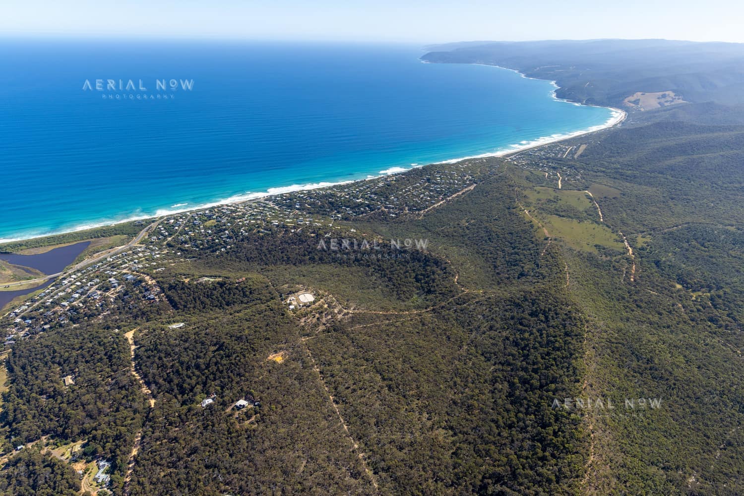 Aerial view of Fairhaven Beach in Fairhaven VIC, showing the surf coastline, residential streets, coastal bushland and blue ocean along the Great Ocean Road region.