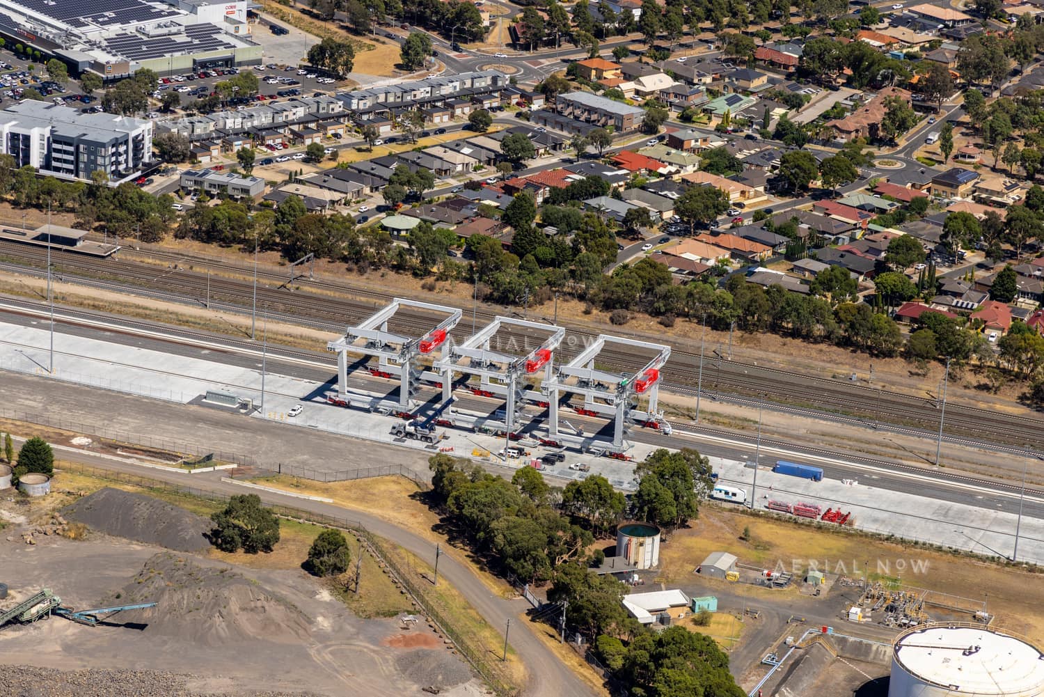 Aerial view of the Somerton rail freight terminal area with gantry cranes, rail sidings, freight handling infrastructure and nearby industrial land in Victoria.