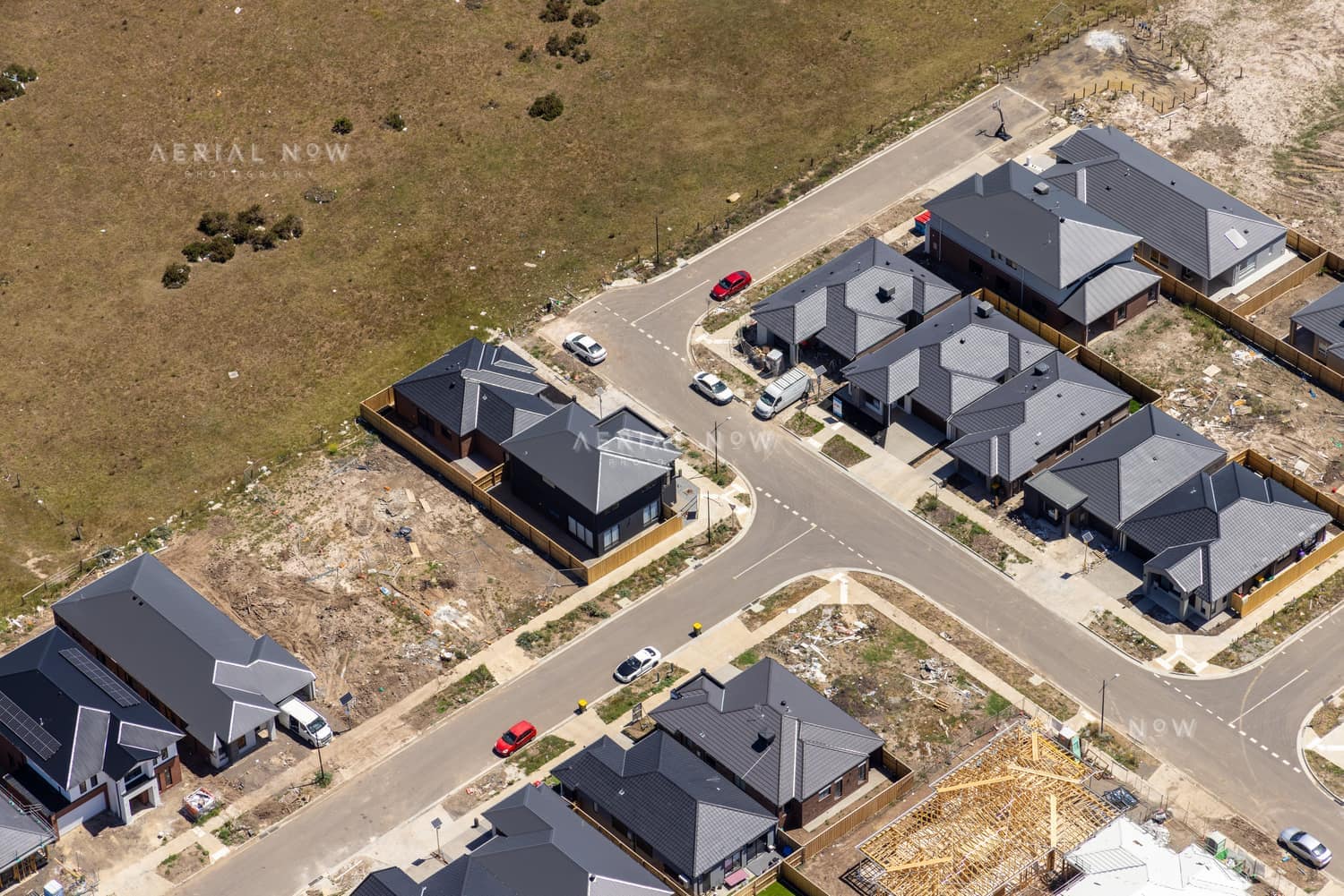 Aerial view of modern houses, vacant lots and local streets around Chilworth Street in Donnybrook VIC.