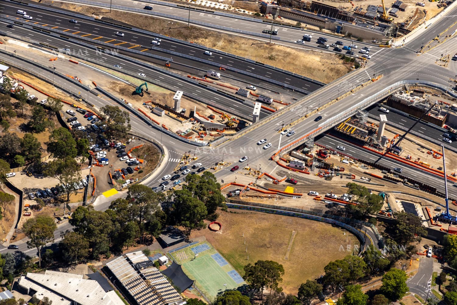 Aerial view of Bulleen Road crossing the Eastern Freeway in Balwyn North, with active road construction, traffic lanes, work zones, parked vehicles and surrounding trees.