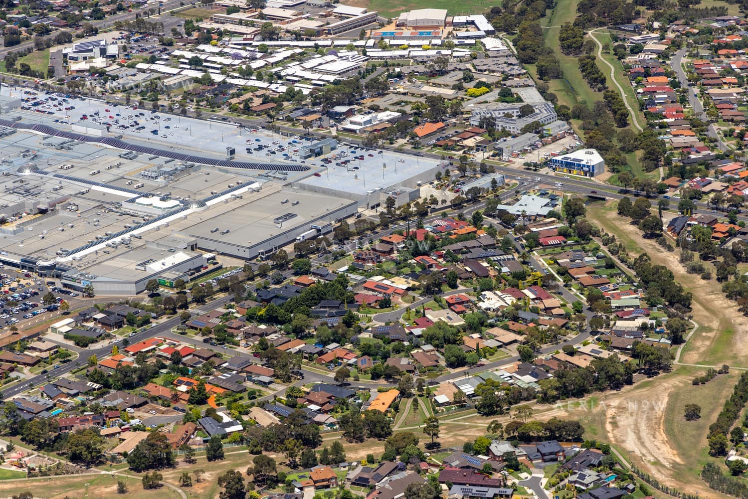 Aerial view of Pacific Werribee shopping centre beside Heaths Road, with large car parks, surrounding residential streets and parkland in Hoppers Crossing VIC.