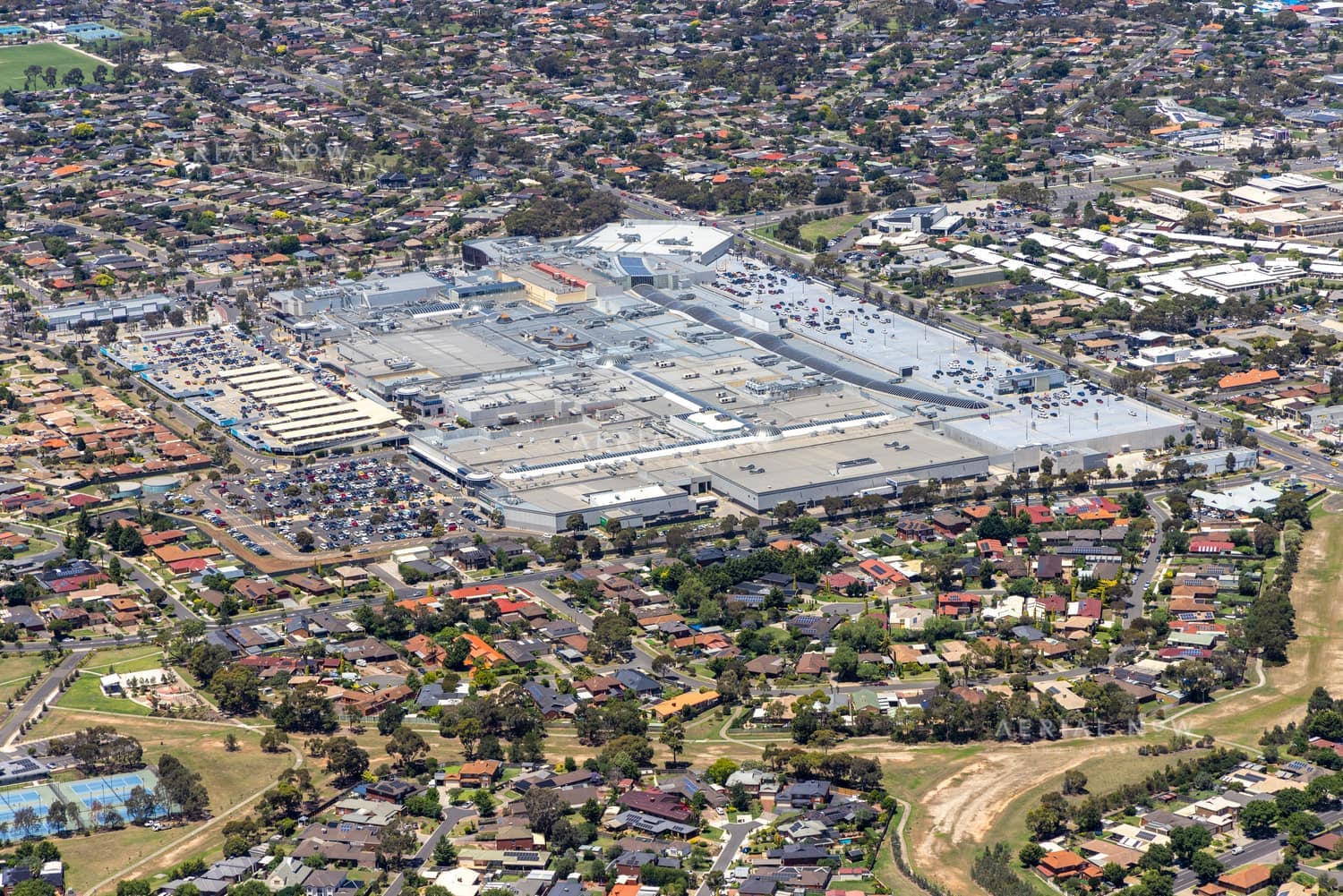 Aerial view of Pacific Werribee shopping centre in Hoppers Crossing, showing large retail buildings, car parks, surrounding suburban streets and residential neighbourhoods.