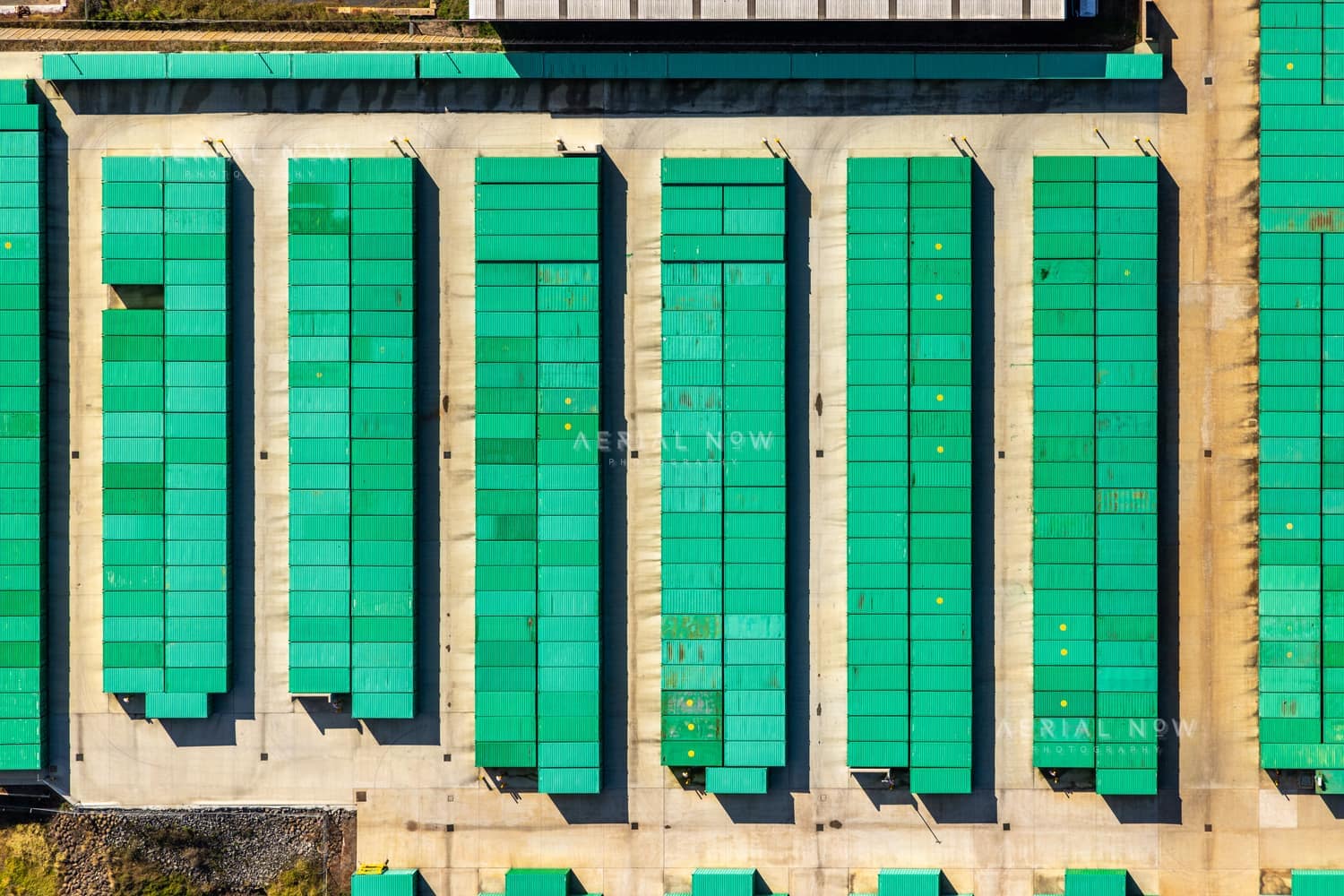 Aerial view of rows of green-roofed storage units and concrete driveways in Harristown, Toowoomba, Queensland.