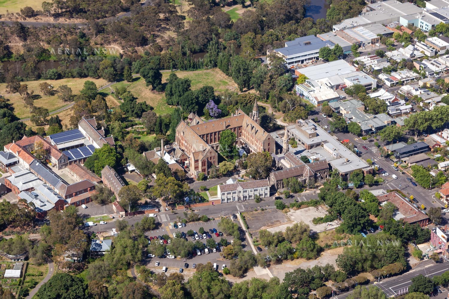 Aerial view of Abbotsford Convent in Abbotsford VIC, showing the historic convent buildings, gardens, car parking, nearby streets and surrounding parkland.