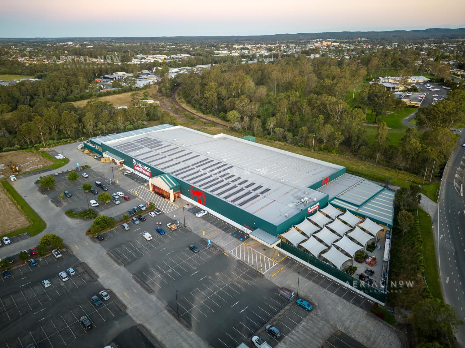 Aerial view of Bunnings Warehouse Taree on Wingham Road with car parking, surrounding trees and nearby commercial areas in Taree NSW.