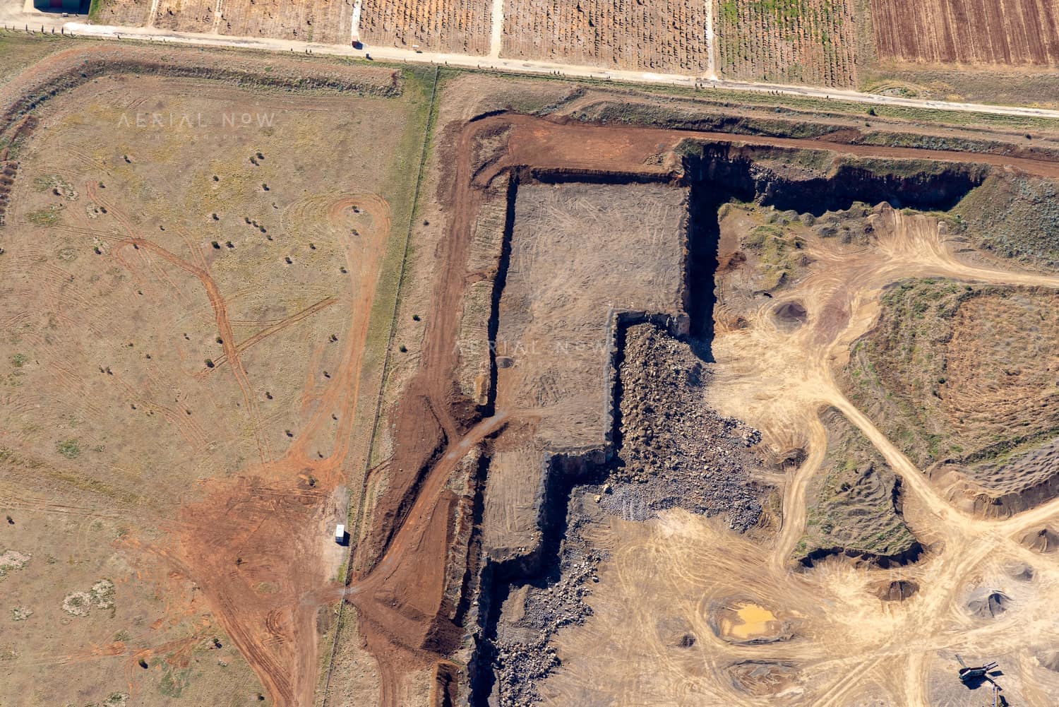 Aerial view of a quarry excavation beside rural paddocks and farm tracks near Mount Cottrell Road in Melton, Victoria.
