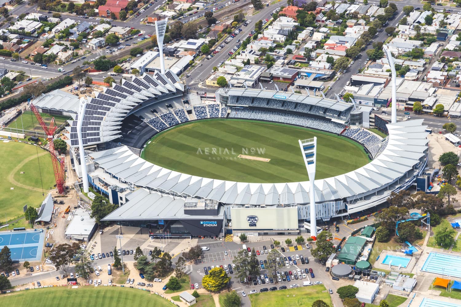 Aerial view of GMHBA Stadium at Kardinia Park in South Geelong, showing the oval, grandstands, light towers, car parking and surrounding streets.