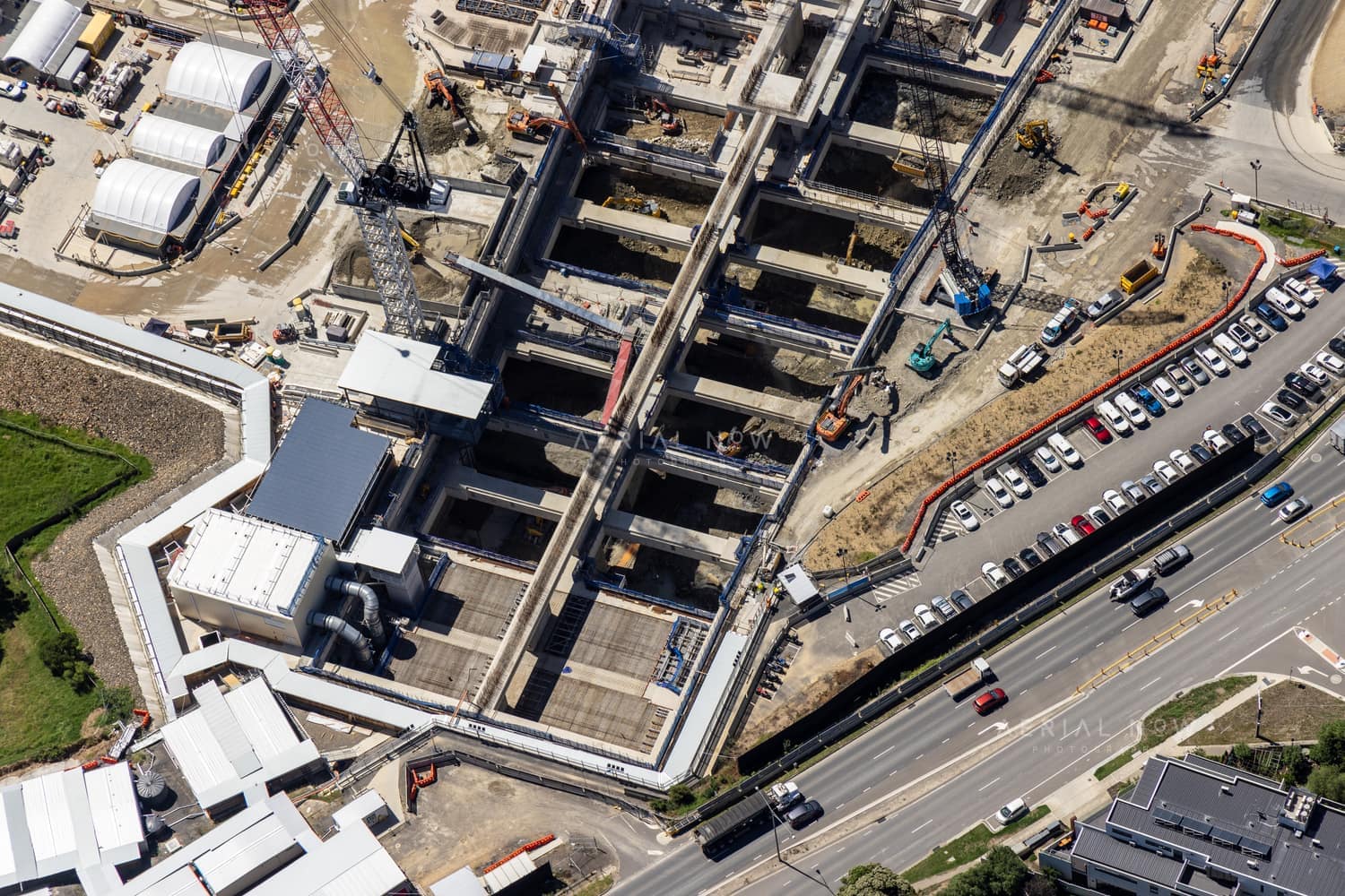 Aerial view of the North East Link construction site beside Bulleen Road in Bulleen, showing excavated concrete works, cranes, machinery, parked vehicles and traffic.