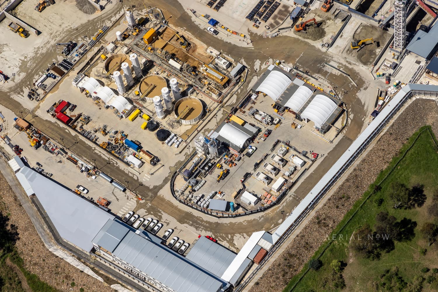 Aerial view of the North East Link construction site in Bulleen showing work sheds, silos, machinery, access roads and equipment within a large compound.