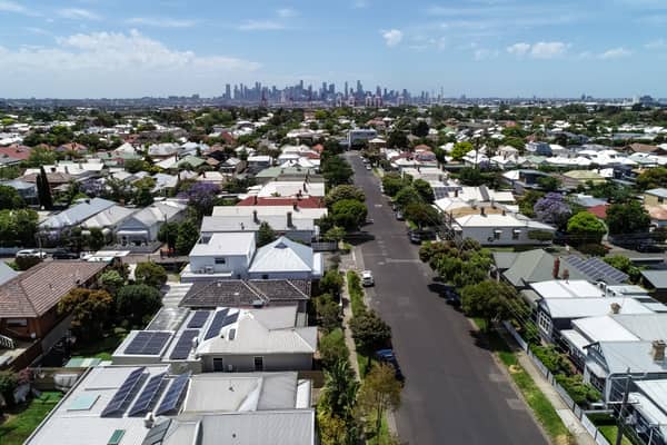 Aerial view over residential streets and rooftops in Yarraville, with the Melbourne CBD skyline visible in the background.