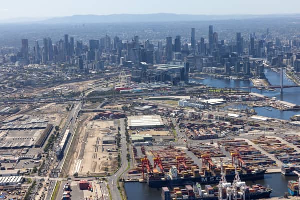Aerial view of the Port of Melbourne container terminal in West Melbourne with shipping containers, cranes, an MSC vessel, Bolte Bridge and the Melbourne CBD skyline in the background.