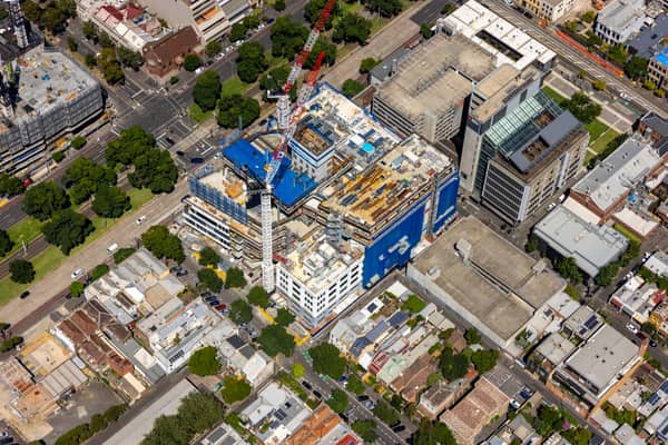 Aerial view of Australian Catholic University’s Saint Teresa of Kolkata Building under construction in Fitzroy on 7 February 2022, with cranes and incomplete upper levels visible.