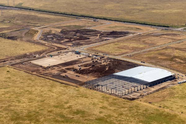 Aerial view of warehouse construction at Agar Industrial Estate Stage 4 on Middle Road, Truganina, showing steel framing, a partially roofed warehouse, earthworks, newly built estate roads and open land.