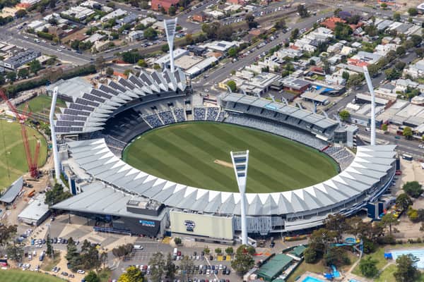 Aerial view of GMHBA Stadium in Kardinia Park, South Geelong, showing the oval, grandstands, roof structures, light towers, nearby streets, car parks and a construction crane.