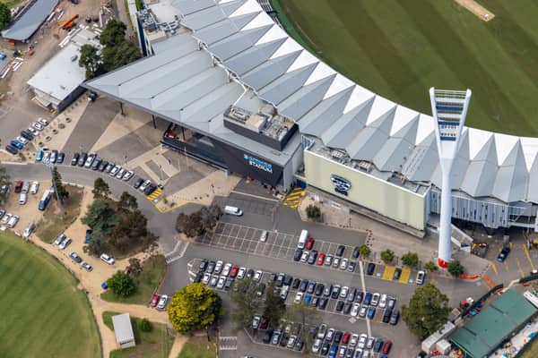 Aerial view of GMHBA Stadium at Kardinia Park in South Geelong, showing the grandstand roof, Cats signage, light tower, football oval edge and surrounding car parks.