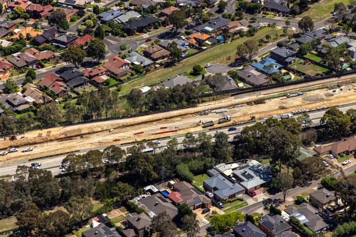 Aerial view of the North East Link construction corridor running beside suburban homes in Watsonia North, Victoria.