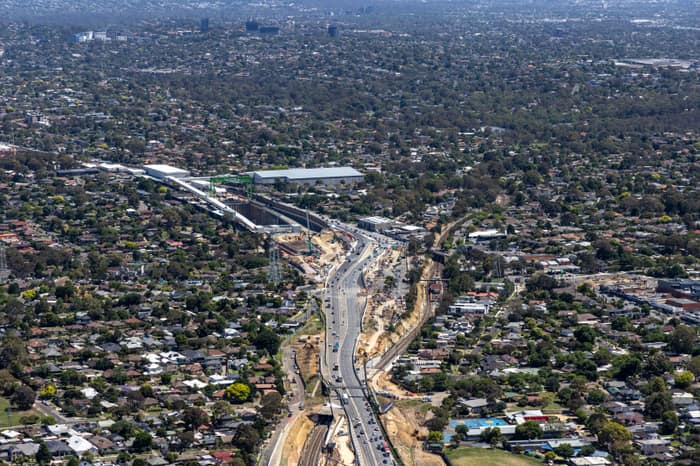 Aerial view of North East Link construction works along Greensborough Road in Watsonia, with traffic, earthworks and surrounding suburban homes.