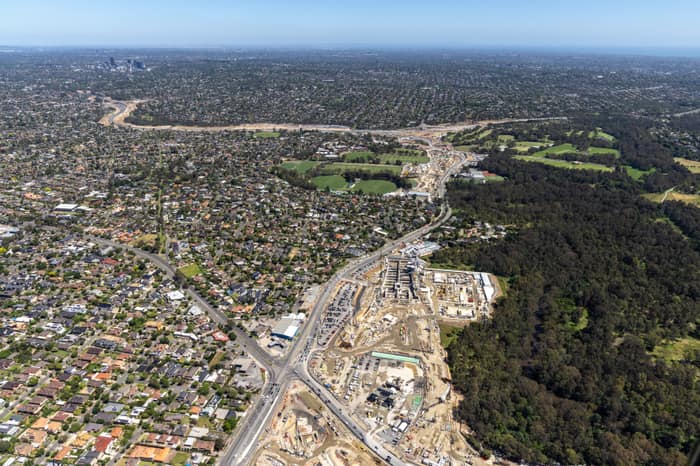 Aerial view of North East Link construction works in Bulleen VIC, with major road works, excavation areas, residential streets and surrounding parkland visible.