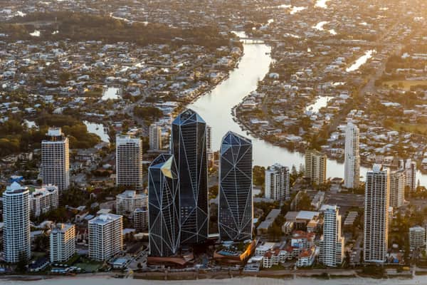 Aerial view of the Jewel Gold Coast towers on the Surfers Paradise beachfront with high-rise buildings, beach sand and inland Gold Coast waterways behind.