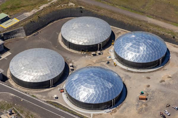 Aerial view of four large covered utility process tanks with faceted membrane roofs, access roads, earthworks and service vehicles in Craigieburn, Victoria.