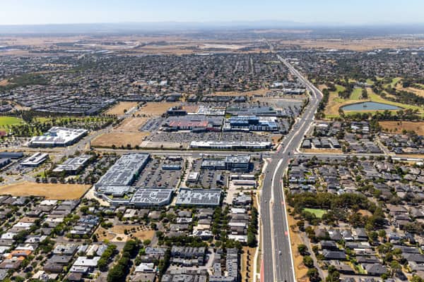 Aerial view of the Craigieburn Road commercial precinct in Craigieburn, with major roads, shopping centre car parks, housing estates and parkland visible.