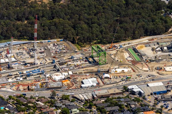 Aerial view of North East Link construction works in Bulleen VIC, showing cranes, work zones, temporary structures, roads and surrounding bushland.