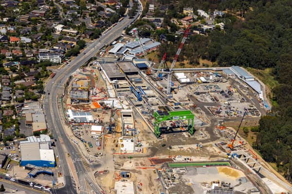Aerial view of the North East Link construction site in Bulleen VIC, showing cranes, work zones, roadworks, surrounding suburban streets and bushland.