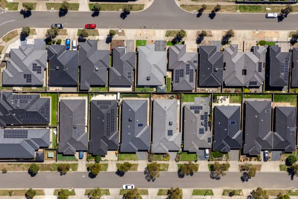 Aerial view of residential homes along Haldon Avenue in Mickleham VIC, showing modern roofs, driveways, street trees and parked cars.