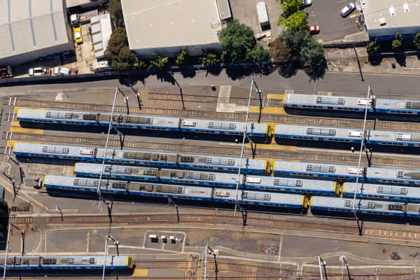 Aerial view of the Epping railway stabling yard in Epping VIC, with multiple suburban trains parked on parallel tracks beside Railway Road and industrial buildings.