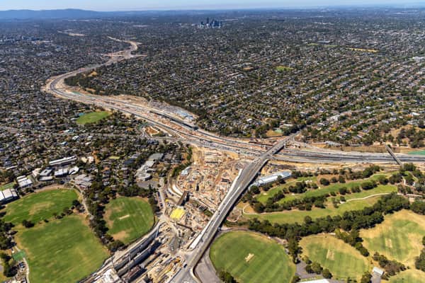 Aerial view of North East Link construction works around the Eastern Freeway in Bulleen, with major roadworks, bridges, suburban housing, sports fields and parkland visible.