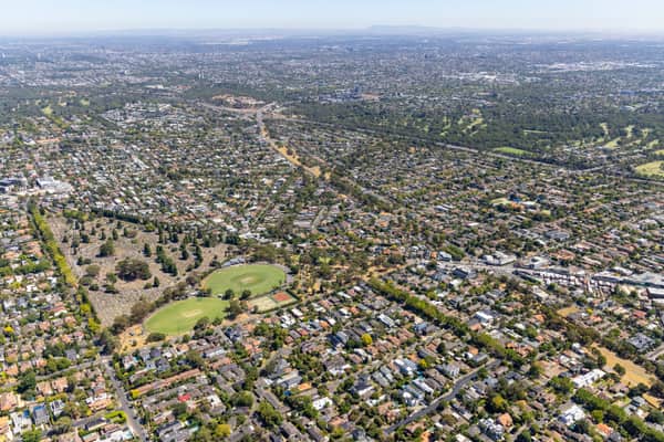 Aerial view of Boroondara General Cemetery in Kew, with surrounding residential streets, sports ovals, parkland and Melbourne suburbs extending into the distance.