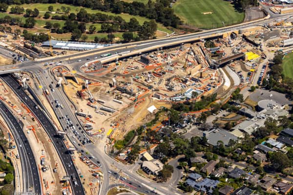 Aerial view of Eastern Freeway and Bulleen Road interchange construction in Balwyn North, with traffic, work zones, sports fields and residential streets around the site.
