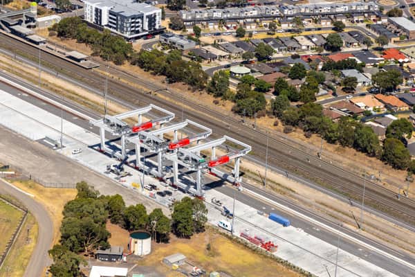 Aerial view of the Somerton rail freight terminal area with gantry cranes, rail sidings, adjacent tracks, industrial land and nearby housing in Somerton, Victoria.