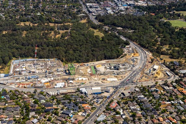 Aerial view of North East Link construction works in Bulleen, with road alignments, work zones, homes, parkland and suburban streets.