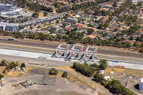 Aerial view of road and rail infrastructure through Somerton industrial land, with warehouses, work sites and nearby residential streets in Melbourne, Victoria.