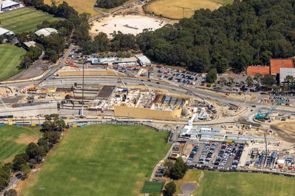 Aerial view of North East Link construction works with road infrastructure, work zones, car parks and sports fields in Bulleen, Victoria.