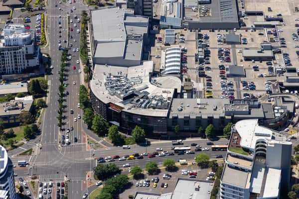 Aerial view of Westfield Doncaster in Doncaster VIC, showing rooftop parking, surrounding commercial buildings, Doncaster Road traffic and nearby intersections.