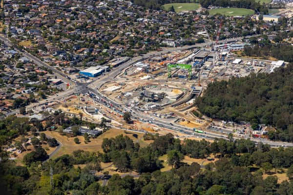 Aerial view of the North East Link construction site in Heidelberg, showing roadworks, construction zones, suburban streets, parkland and surrounding residential areas.