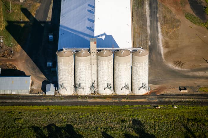 Aerial view of grain silos beside a rail corridor and agricultural storage sheds in Moree, New South Wales.
